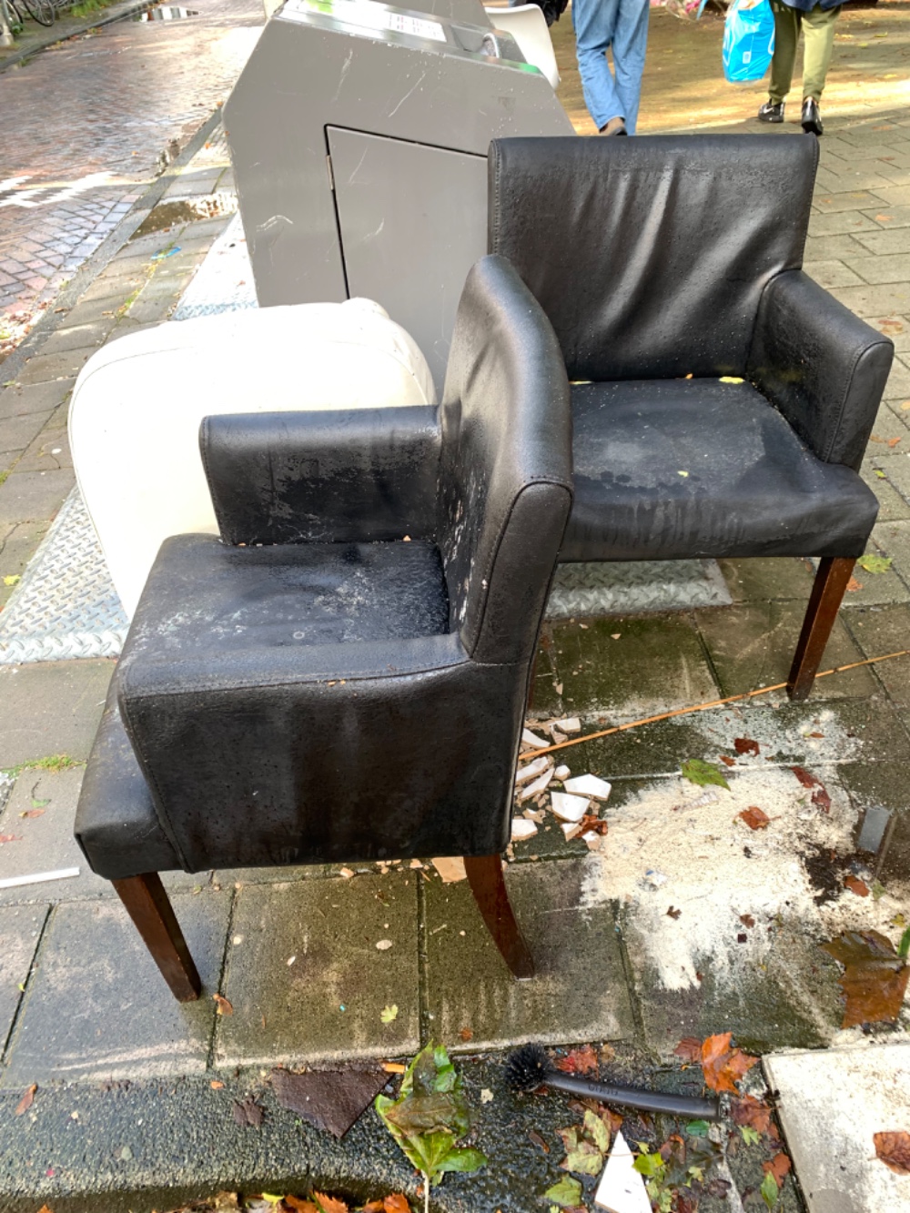 2 black leather (not real) chairs and a puff