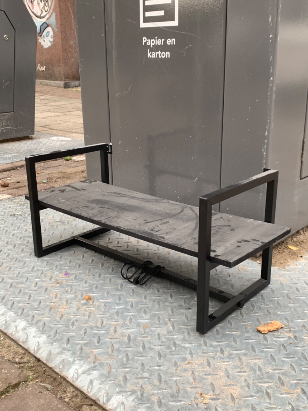 A black shelf with hooks for clothes