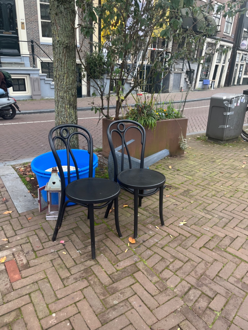 Three black chairs, a latern (without light buks, I think it’s for a candle), two big blue plastic planters as wel as a smaller white metal planter. 