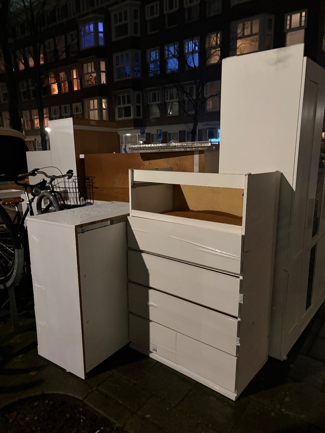 Meerdere ikea kasten, een bankje en koelkast