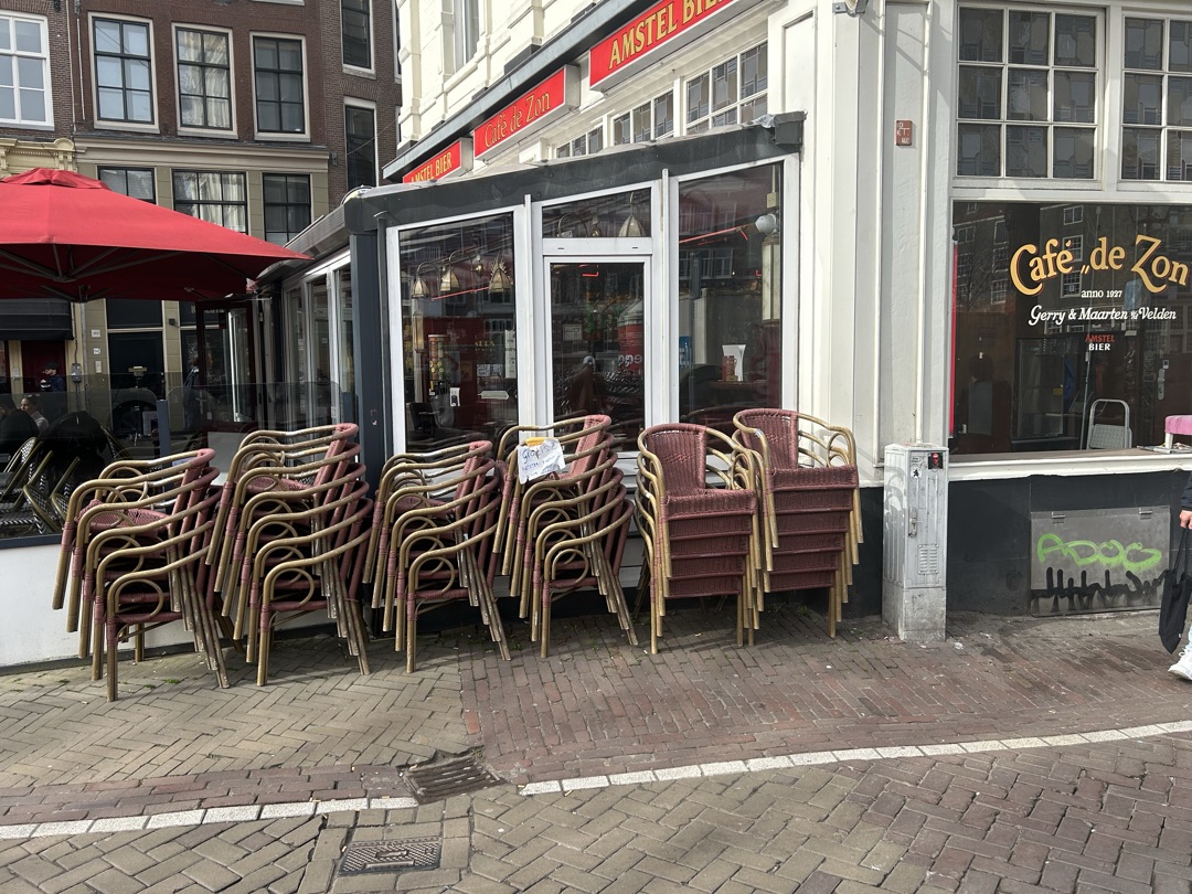 Oude terrasstoelen van Café De Zon, met papiertje ‘Gratis mee te nemen’.