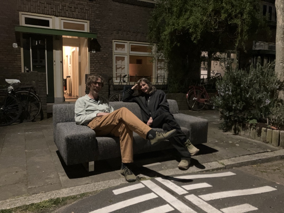 Twee-en-halfzitsbank (195 cm breed) gemêleerde antracietkleurige stof, met brede armleuningen en verchroomd stalen onderstel, met brandplek bij rechterleuning. Aan de straat op Bucheliusstraat 12 in Tuinwijk, Utrecht 1