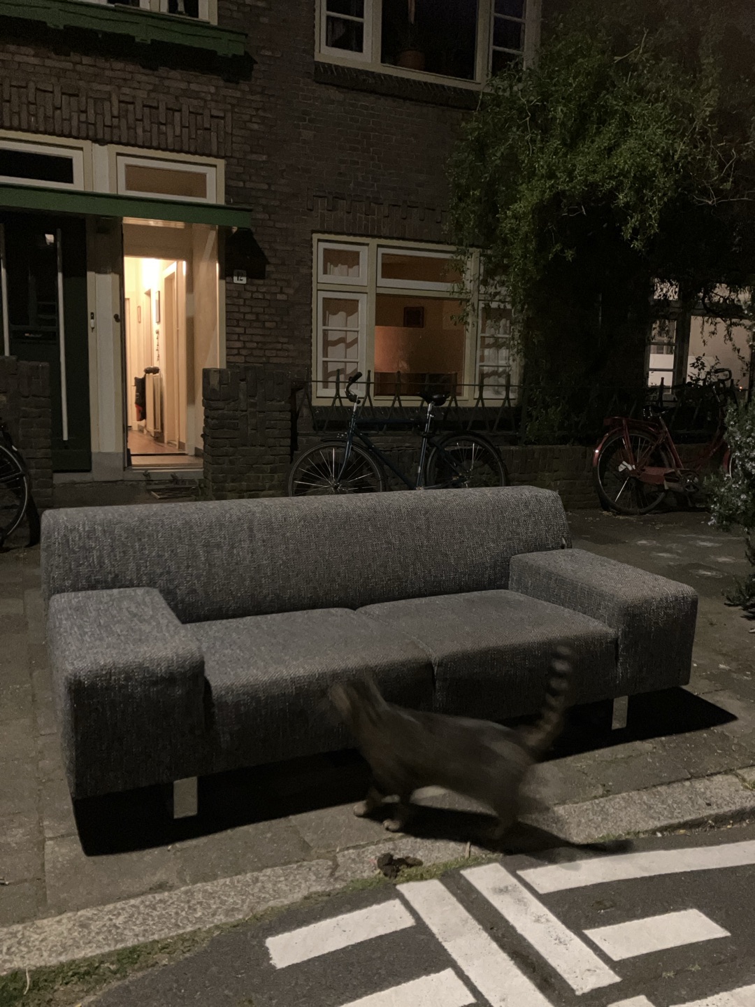 Twee-en-halfzitsbank (195 cm breed) gemêleerde antracietkleurige stof, met brede armleuningen en verchroomd stalen onderstel, met brandplek bij rechterleuning. Aan de straat op Bucheliusstraat 12 in Tuinwijk, Utrecht 2