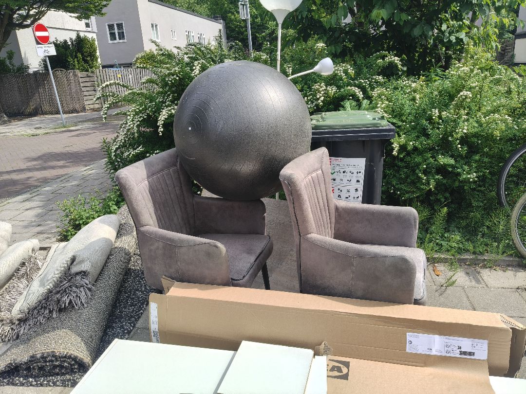 Kleden en stoelen in goede staat in Betondorp bij de container in de Akkerstraat 1