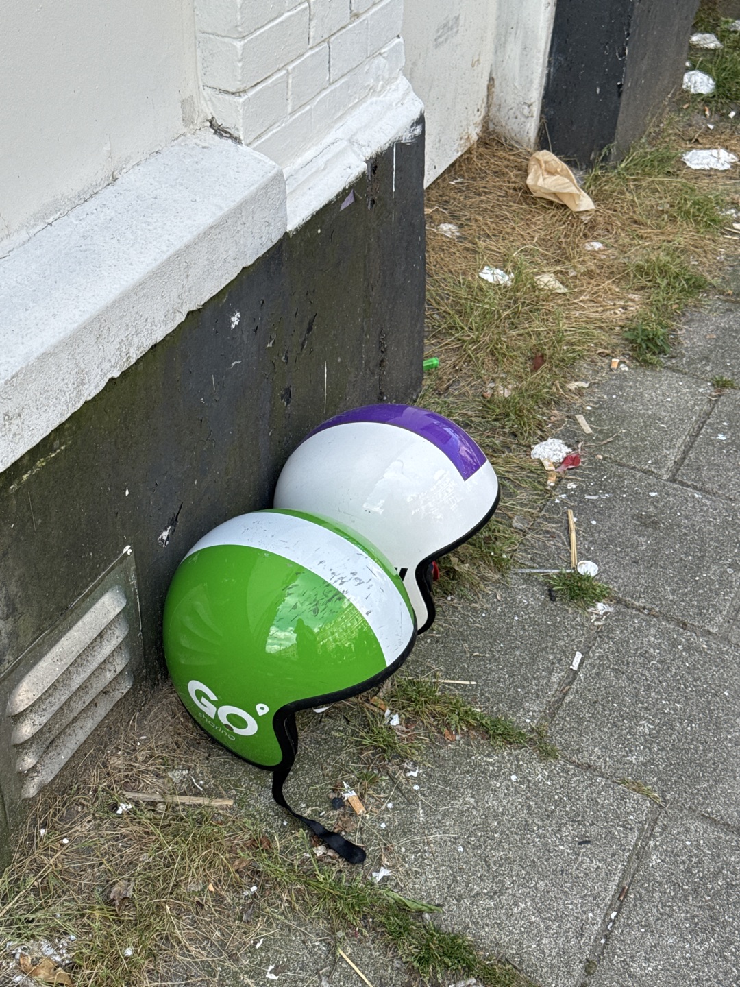 Two helmets that are from ride sharing companies but have been abandoned and saved from the trash 1